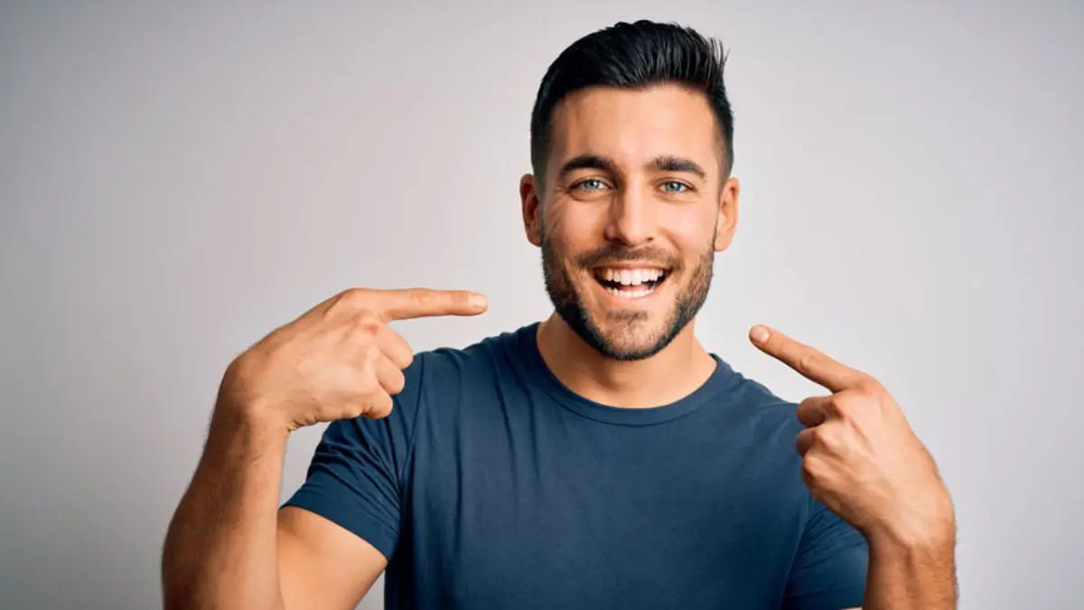 Man Pointing At His Teeth After Teeth Whitening