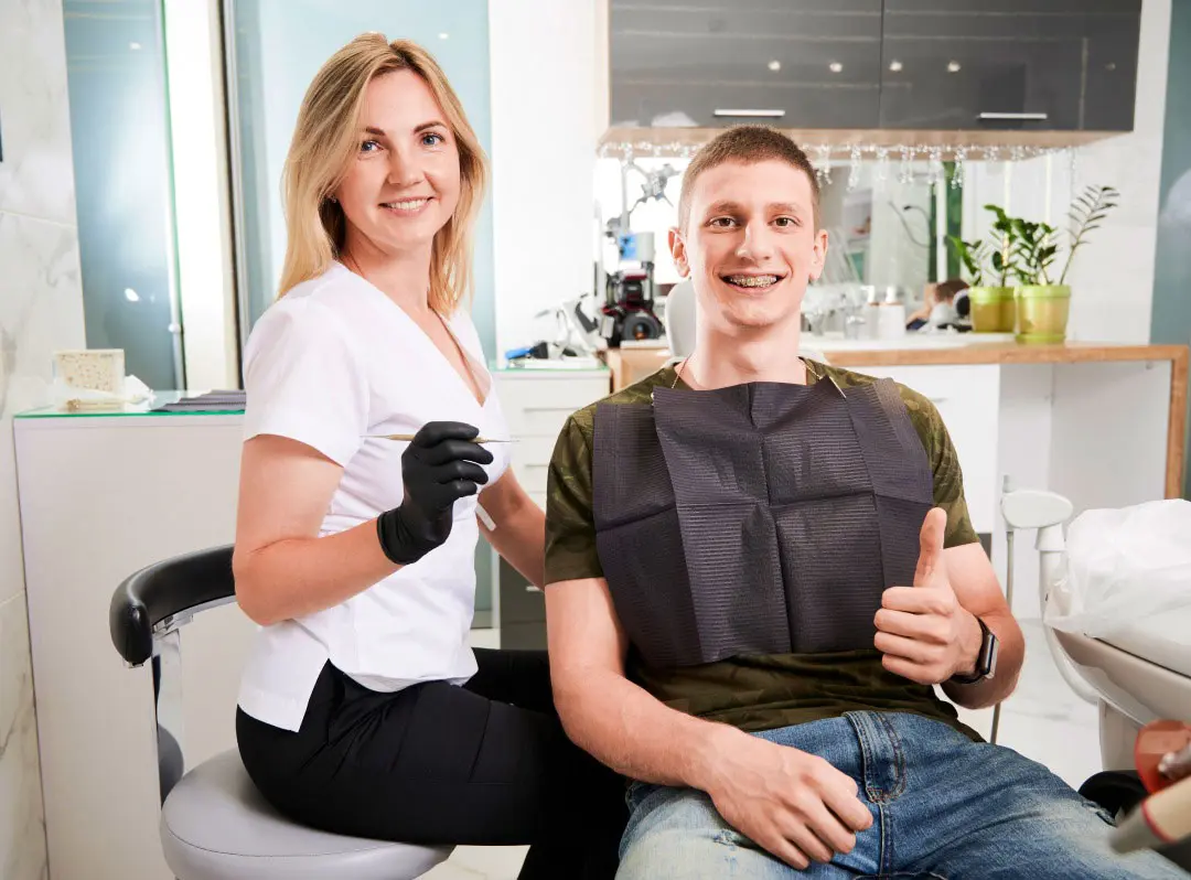 A Dentist Sitting In A Chair Next To A Patient