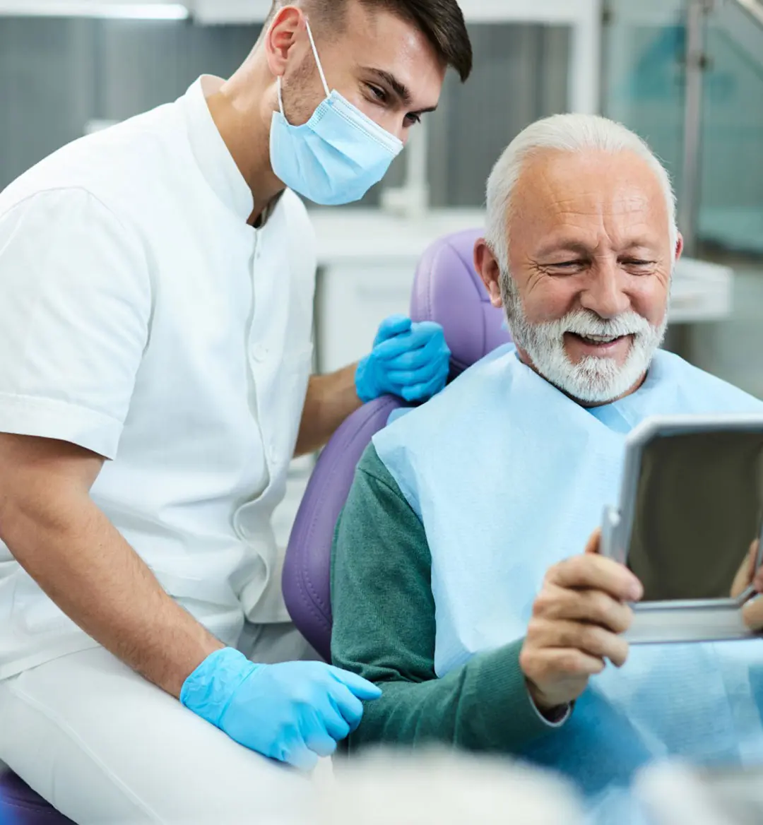 Dentist And Patient Looking At Mirror During Dental Checkup